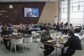 A mullah is seen on a large screen in a modern restaurant at a motorway service station, 13.03.2019