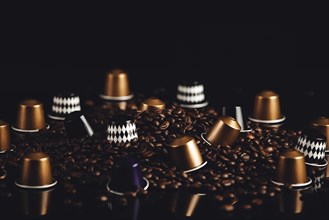 Scattered coffee capsules and coffee beans on a dark background