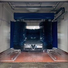 View of a car wash, Alfa Romeo being washed in a car wash with textile brushes, Germany, Europe
