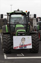 Sign with drawn Minister of Agriculture Cem Oezdemir on a tractor, farmer protests, demonstration