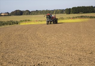 Farm machinery spraying Glyphosate herbicide on an arable field near Hollesley, Suffolk, England,