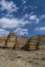 Colourfully painted Buddhist stupa, in a eroded mountain landscape, Kingdom of Mustang, Nepal, Asia