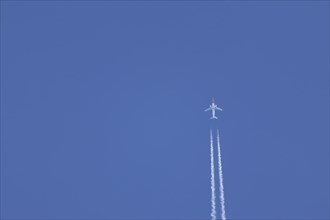 Boeing 737 jet aircraft in flight with a contrail or vapour trail behind in the sky, England,