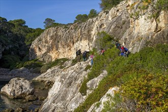 Group of hikers traversing a rocky nature trail in a forested area, Coastal Hiking tour in the