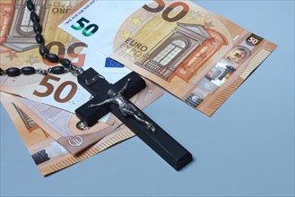 Crucifix and banknotes, church and money, church tax