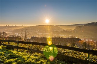 Early morning with sunrise behind a fence separating a field from houses, Arrenberg, Elberfeld,