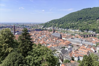 Sweeping views over the rooftops of a city with church towers and green hills, Heidelberg,
