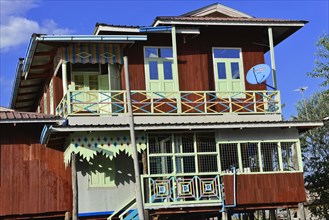 Wooden house on stilts with colourful decorations and satellite dish, Inle Lake, Myanmar, Asia