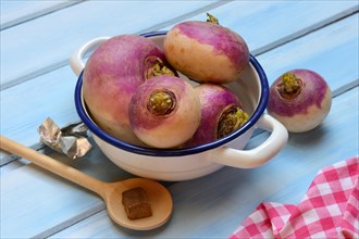 Purple turnips in pot and cooking spoon with stock cube, Brassica rapa