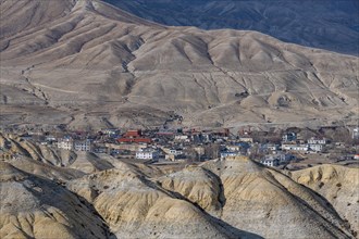 Lo Manthang, capital of Upper Mustang, viewed from a distance amidst a barren desertic landscape,