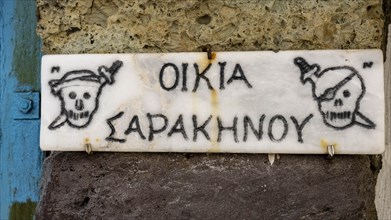 Sign on pirate motifs, climate, Milos, Cyclades, Greece, Europe