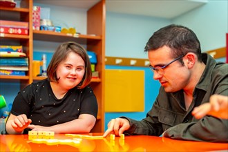 People with special needs playing board skill games in a day center