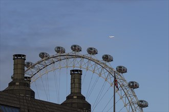 Airbus A319-100 aircraft of British airways in flight over the pods of the London Eye or Millennium