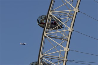Airbus A319-100 aircraft of British airways in flight behind the pods of the London Eye or