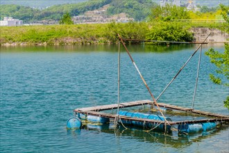 Rustic homemade floating dock with barrels on a calm river, in South Korea