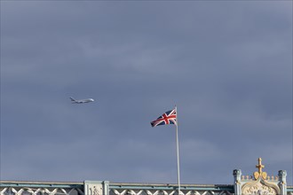 Airbus A380 aircraft of Emirates airlines in flight with a Union Jack flag on Tower Bridge in the
