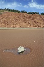 Erratic boulder on the beach at low tide, cliffs, red sandstone, Five Islands Provincial Park,