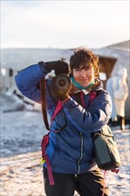 Portrait of adventurous photographer woman smiling in winter in Iceland on the plane in