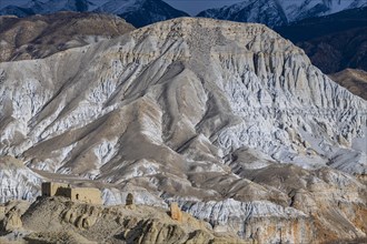 Eroded sandstone houses in barren mountain landscape, Kingdom of Mustang, Nepal, Asia