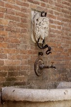 Detail of the Mencia Fountain in the historic centre of Asciano, Crete Senesi, Tuscany, Italy,