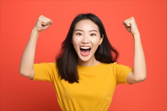 Happy successfull Asian woman cheering in front of orange background. KI generiert, generiert AI