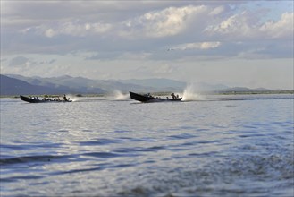 Fast-moving boats leave tracks on the water, surrounded by nature, Inle Lake, Myanmar, Asia