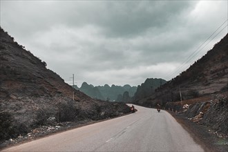 Dark and moody cinematic scenery of an empty road to the mountains in Dong Van, Vietnam, Asia