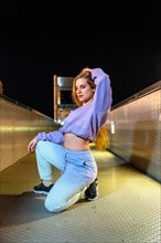 Vertical portrait of a caucasian blonde and sensual young woman with urban hip hop style outdoors