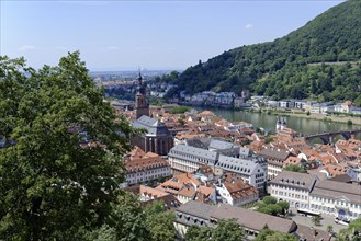 Panoramic view of an old town by the river (Neckar), with church and mountain in the background,