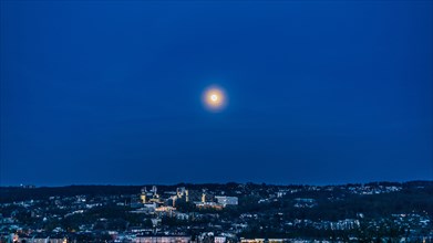 Full moon over a city at night with a hilly landscape and subdued lighting, Bergische Universitaet,