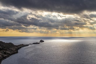 Dramatic sunset over the sea with a serene coastline under cloud-filled sky, Coastal Hiking tour in