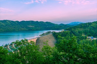 Scenic view of a dam on a lake surrounded by mountains at dusk, in South Korea