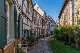 Historic cobbled street with a garden on one side and half-timbered houses, Old Town, Hattingen,