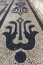 Traditional Portuguese tile pattern, cobblestone pavement in the pedestrian zone of the old town,