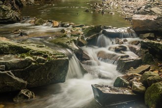 Closeup of water from small mountain stream cascading over rocks and boulders in South Korea