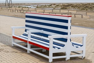 An empty, colourfully striped beach chair on the beach promenade, Zeebrugge, Flanders, Belgium,