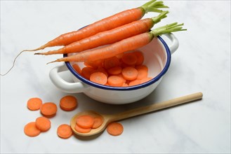 Carrots and carrot slices in pot, Daucus carota