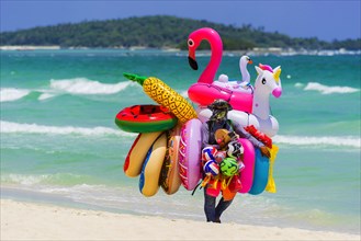 Merchant on the beach selling inflatable swimming aids, colourful, swimming, beach vendor, holiday,