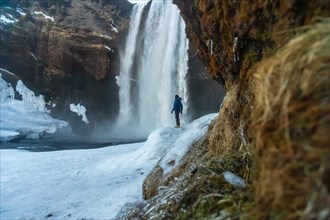 Silhouette of woman in winter in Iceland under the Skogafoss waterfall with temperatures of 20
