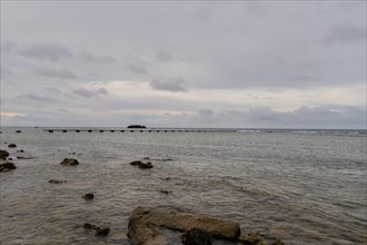 Seascape of the pacific ocean with a rocky shoreline taken in Guam on a cloudy day in Guam