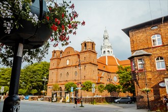 Panorama of Nikiszowiec brick architecture with flowers in the foreground in focus, Katowice,