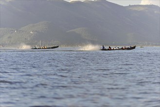 Motorboat travelling at high speed on a lake, mountains in the background, Inle Lake, Myanmar, Asia