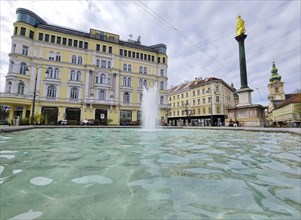 Graz, Austria, 26.03.2023: Mary's Column and fountain in Jakominiplatz Square and Parish Church in