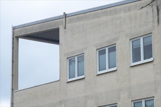 Corner of a modern building with minimalist windows and concrete construction