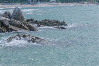 Rocky beach with waves under an overcast sky, in South Korea