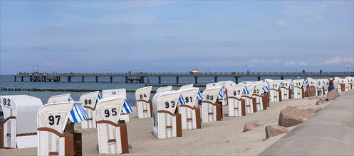 White beach chairs on the beach, behind the pier in Kuehlungsborn, Mecklenburg-Vorpommern, Germany,