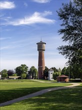 Brick water tower stands on a green lawn under a clear blue sky, Ladenburg, Baden-Wuerttemberg,