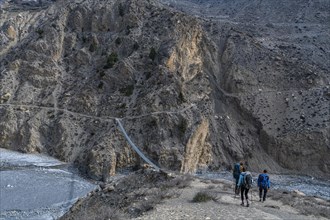 Tourists hiking a huge hanging bridge, Kingdom of Mustang, Nepal, Asia