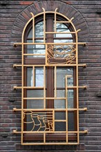 Artfully decorated Art Nouveau window on a historic brick facade