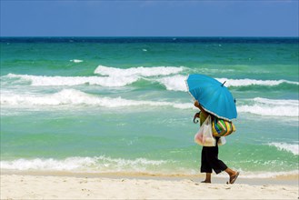 Woman on the beach with parasol as sun protection, ozone, heat, protection, light protection,